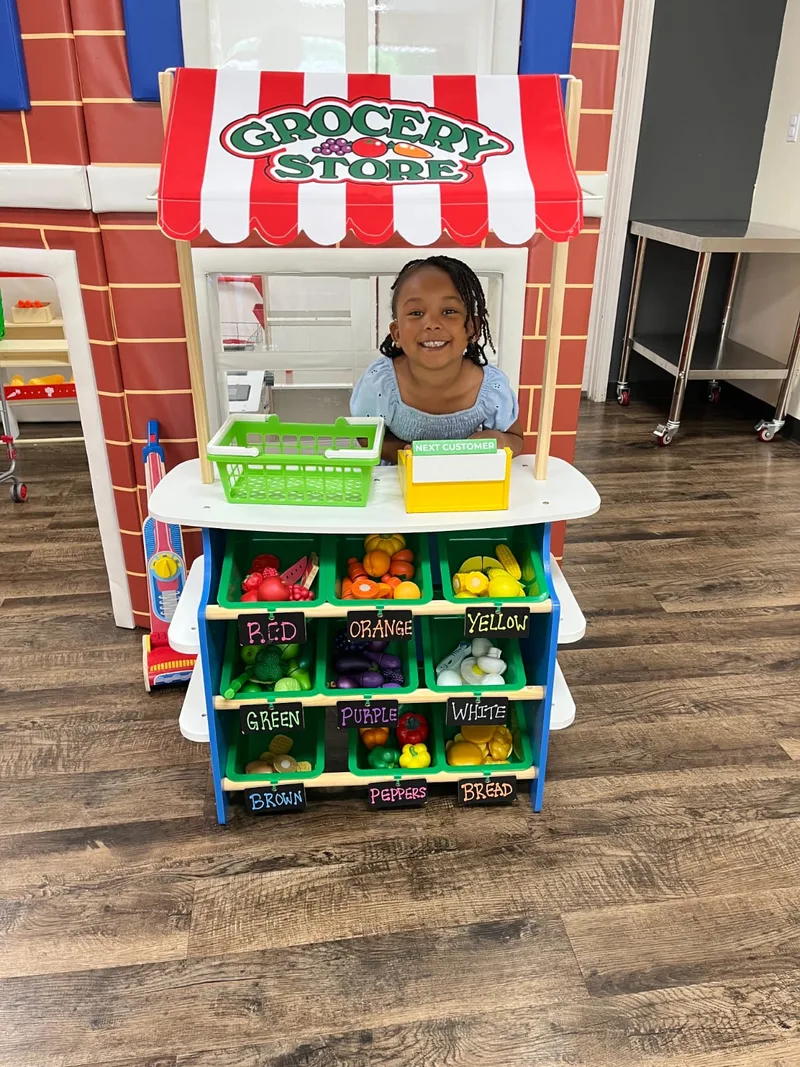 Child playing at the Fresh Play pretend grocery stand